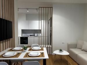 a kitchen and living room with a table and chairs at LARIMAR Lungomare Vlore in Vlorë