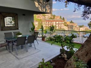 un patio avec une table et des chaises sur un balcon dans l'établissement Villa Centaurea Apartment with private parking, à Taormine