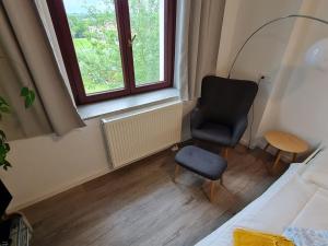 a bedroom with a chair and a window at Ausblick Freital 5 in Freital