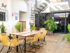 a table and chairs in a room with plants at La Casa de Mamapán Hotel Colonial Ahuachapan in Ahuachapán