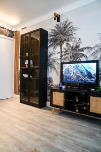 a living room with a flat screen tv on a entertainment center at La Belle Escale d'Epinay aux portes de Paris in Épinay-sur-Seine