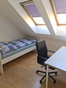 a bedroom with a bed and a desk and a chair at Rodinný dům v Praze s bazénem in Prague