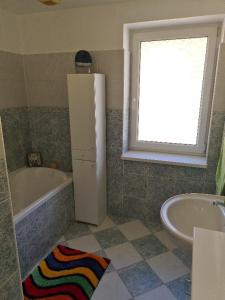 a bathroom with a refrigerator and a tub and a sink at Rodinný dům v Praze s bazénem in Prague +4 photos