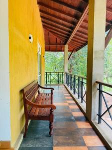 a bench sitting on the porch of a building at Ranmin Eco Village in Kataragama +2 photos