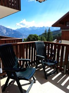 two chairs on a balcony with a view of mountains at Appartement avec balcon - 2 personnes in Puy-Saint-Vincent
