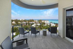 a balcony with chairs and a view of the ocean at 2 Bed Ocean View Condo at ONE Cable Beach in Nassau