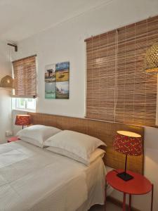 a bedroom with a bed and a window with blinds at La villa detente 1 - une experience authentique in Rodrigues Island +13 photos