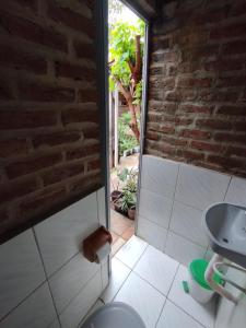 a bathroom with a sink and a brick wall at O Candeeiro - Hostel Acampamento in Arcoverde
