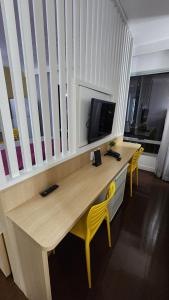 Un escritorio de madera con dos sillas amarillas en una habitación. en Joia Rara no Hotel Mercure, en Manaus