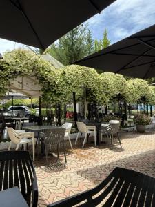 a patio with tables and chairs under an umbrella at GRAND HOTEL eae in Durrës