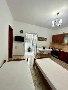 a room with two beds and a kitchen with a table at Chris apartament 2 in Polisi i Vogël