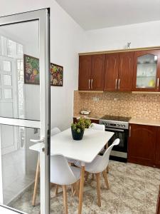 a kitchen with a white table and white chairs at Chris apartament 2 in Polisi i Vogël