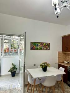 a kitchen and dining room with a white table and chairs at Chris apartament 2 in Polisi i Vogël