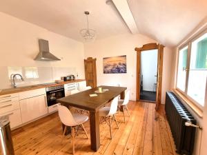 a kitchen with a wooden table and white chairs at Binderburg, Jena in Jena