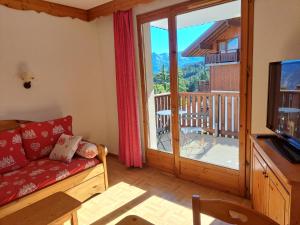 a living room with a couch and a large sliding glass door at Appartement avec balcon - 2 personnes in Puy-Saint-Vincent +10 photos