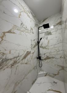 a white marble shower with a light in a bathroom at Batumi Luxury Panoramic Sea View Apartment in Angisa +25 photos