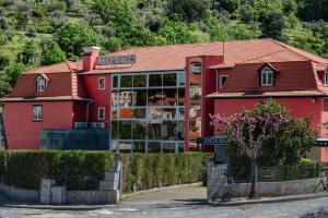 雷森迪Douro Marina Hotel & SPA的红色的建筑,有红色的屋顶