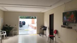 a living room with a tv on a wall at Recanto sao miguel in Ilhéus