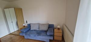 1 dormitorio con sofá azul y 2 almohadas en Apartment hauskaernten, en Velden am Wörthersee