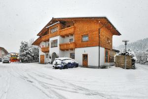 a snow covered house with a car parked in front of it at Haus Salzburgerland in Altenmarkt im Pongau