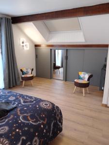 une chambre avec un lit et des chaises dans une pièce dans l'établissement Lac et étoiles, à Savines