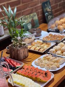a table with a bunch of different types of pastries at Pousada Zoe in Pirenópolis