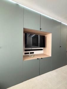 a kitchen with grey cabinets and a microwave at Duchesse Luxe Cap - Naturiste in Cap d'Agde