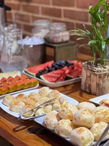 a table topped with plates of pastries and fruit at Pousada Zoe in Pirenópolis +14 photos