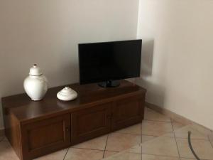 a flat screen tv sitting on top of a wooden cabinet at Casa dei Nonni in San Damiano dʼAsti
