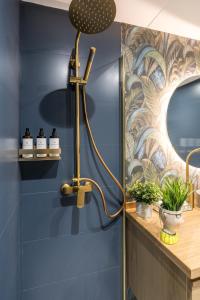 bagno con doccia e parete blu di Constanza, la vecina de Cervantes ad Alcalá de Henares