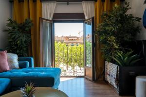 un soggiorno con divano blu e porta scorrevole in vetro di Constanza, la vecina de Cervantes ad Alcalá de Henares