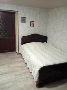 a bedroom with a large bed with a white blanket at Guesthouse - Happy house in Kutaisi in Kutaisi