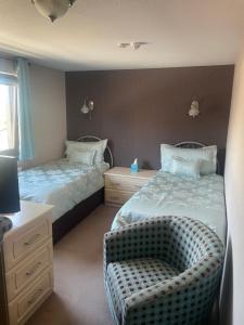 a bedroom with two beds and a chair in it at Albert Villa Guest House in Perth