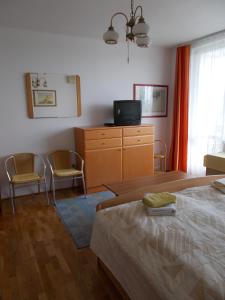 バラトンフレドにあるLiliom Apartments Balatonfüredのベッドルーム1室(ベッド1台、椅子2脚、ドレッサー付)