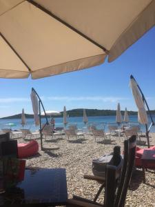 un groupe de chaises et de parasols sur une plage dans l'établissement Bella Casa Srima Comfort, à Srima