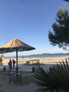 une table et des chaises sous un parasol sur la plage dans l'établissement Bella Casa Srima Comfort, à Srima