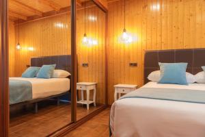 due letti in una stanza con pareti in legno di Apartamento Magariños a Gondomar Altre 13 foto