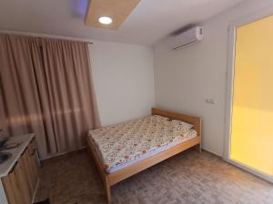 a small bedroom with a bed and a sink at Airport view Apartment in Belgrade