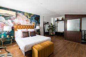 una camera da letto con un letto grande con un dipinto sul muro di Constanza, la vecina de Cervantes ad Alcalá de Henares