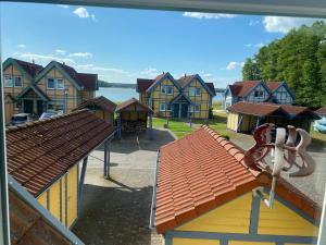 una vista di un gruppo di case e di un parco giochi di Ferienhaus Leuchtturmblick Hafendorf Rheinsberg a Rheinsberg