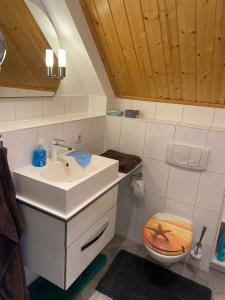 un bagno con lavandino e WC di Ferienhaus Leuchtturmblick Hafendorf Rheinsberg a Rheinsberg Altre 20 foto