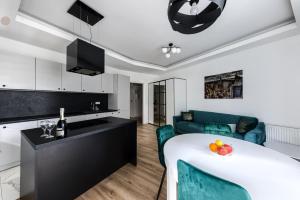kuchnia i salon ze stołem i krzesłami w obiekcie Kazou Residence Arkadia w Warszawie