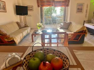 a living room with a bowl of fruit on a table at Sea View Artaki Apartment in Nea Artaki