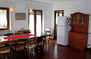 a kitchen with a table and a white refrigerator at Casa Stocke - Relax e natura in Contrà Zocchi in Asiago