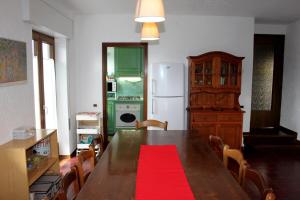 a kitchen with a wooden table with a red rug at Casa Stocke - Relax e natura in Contrà Zocchi in Asiago