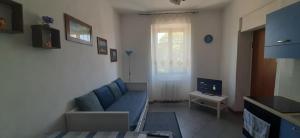 a living room with a blue couch and a television at monolocale Antica Argenteria stazione e centro a due passi in Vercelli