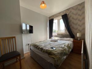 a bedroom with a bed and a window and a television at Birmingham city centre lovely family gateway in Birmingham