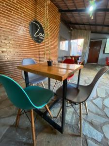 a table and chairs in front of a brick wall at Pousada Zoe in Pirenópolis