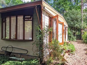a small green house with a window on the side at Bos-Chalet in Diessen