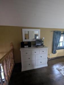 a bedroom with a white dresser with a mirror at Riverside Cottage in Castledawson